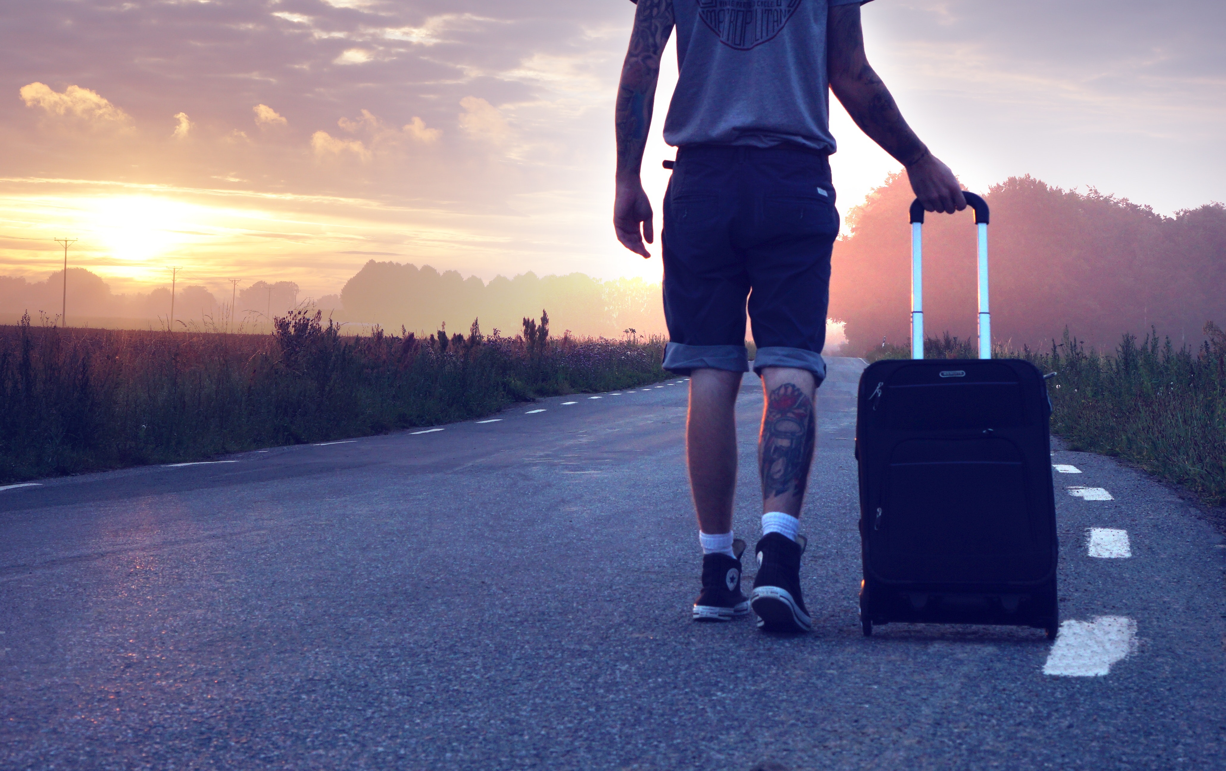 Image of a guy carrying a suitcase out